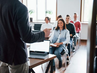 Cheerful mood. Group of people at business conference in modern classroom at daytime.